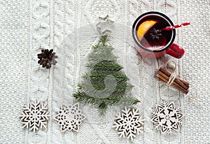 Christmas concept with spruce, fir-tree, cone and mulled wine on white knitted background. Holiday card.