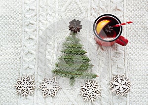 Christmas concept with spruce, fir-tree, cone and mulled wine on white knitted background. Holiday card.