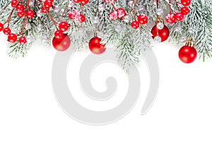 Christmas concept. Xmas border composition with red glass baubles, holly berries and green fir branch isolated on white background