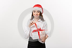 Christmas Concept - young happy caucasian business woman with santa hat smiling while open gift box with copy space on