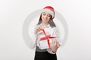 Christmas Concept - young happy caucasian business woman with santa hat smiling while open gift box with copy space on