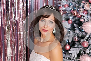 Christmas concept young woman stands next to decorated Christmas tree