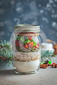 Christmas cookie mix jar. Dry ingredients for cooking Christmas cookies in a jar, dark background.