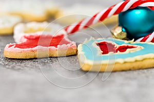 Christmas cookies, bauble and candy cane on grey background
