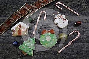 Christmas Cookies with candy canes, ribbon and decorations on wood flat lay