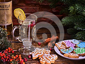 Christmas cookies on plate and glasse mug with cinnamon sticks.