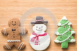 Christmas cookies, snowman, X`mas tree, gingerbread flat lay on wooden cutting board background top view for Xmas party holiday