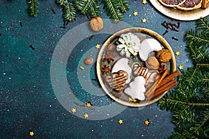 Christmas cookies witch chocolate, gingerbread cookies, nuts and fir twigs on dark background