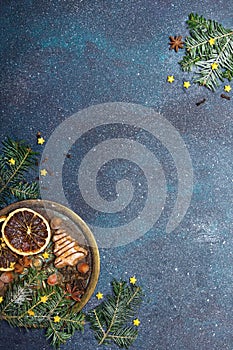 Christmas cookies witch chocolate, gingerbread cookies, nuts and fir twigs on dark background