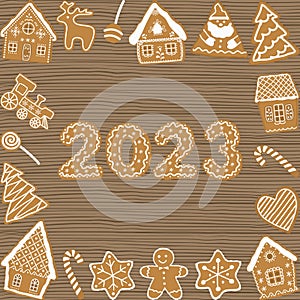 Christmas cookies on wooden background. Holiday background. Gingerbread houses, Santa Claus, deer, fir trees, gingerbread man
