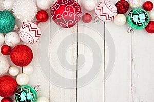 Christmas corner border of red, green and white ornaments on white wood