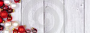 Christmas corner border of red and white ornaments on a white winter wood banner background