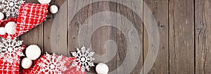 Christmas corner border of red and white ribbon, baubles and snowflake decorations on a dark wood banner background