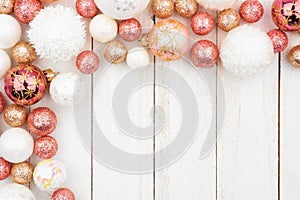 Christmas corner border of rose gold, white and gold ornaments on white wood