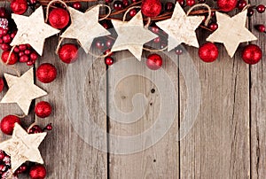 Christmas corner border with rustic wood star ornaments and baubles over aged wood