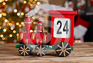 Christmas countdown. Wooden train Christmas advent calendar, with tree lights bokeh.
