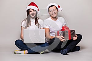 Christmas couple with laptop and gift