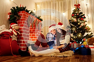 The Christmas couple in love in hats Santa Claus reading a book