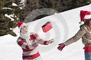 Christmas couple playing with gifts in the snow