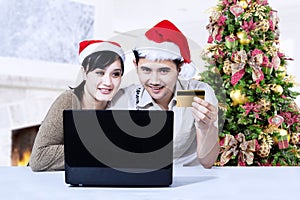 Christmas couple shopping online at home