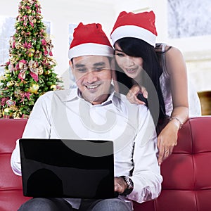 Christmas couple using a laptop