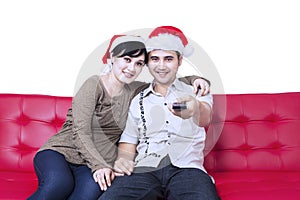 Christmas couple watching TV sitting at sofa