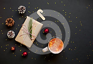 Christmas craft gift boxes with red ribbons, pine cones and red and golden decorations against black background