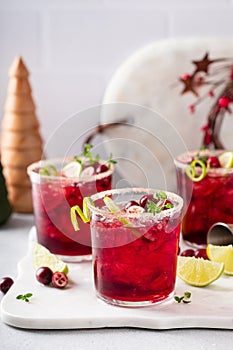 Christmas cranberry and lime margarita cocktail garnished with lime zest