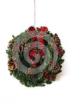 Christmas crown and winter wreath decoration with holly, fir, blue spruce, pine cones on white background.