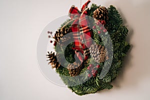 Christmas crown and winter wreath decoration with holly, fir, blue spruce, pine cones on white background.