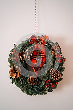 Christmas crown and winter wreath decoration with holly, fir, blue spruce, pine cones on white background.