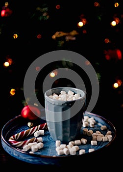 Christmas cup of cocoa with marshmallows against the background of a Christmas tree. New Year\'s mood