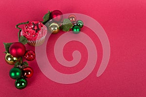 Christmas cupcake and tree ornaments on red background