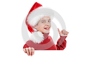 Christmas, cute boy in Santa hat pointing finger