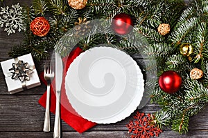 Christmas cutlery with a plate and a red napkin on a wooden background. New year and christmas concept.