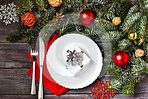 Christmas cutlery with a plate and a red napkin on a wooden background. New year and christmas concept.