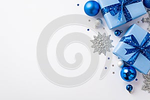 Christmas Day concept. Top view photo of blue white silver baubles big gift boxes with ribbon bows glitter snowflake ornaments and