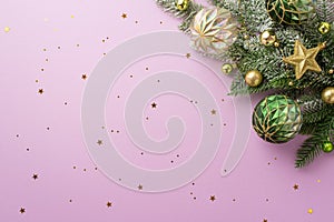 Christmas Day concept. Top view photo of pine branch decorated with star ornament transparent gold and green baubles and shiny