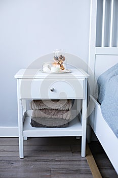 Christmas decor on the bedside table near the bed in the bedroom. Cozy interior details