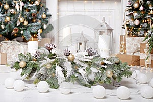 Christmas decor. Christmas tree decorations and holiday homes. New Year`s interior with a fir tree in white tones