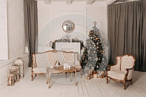 Christmas decor. Christmas tree decorations and holiday homes. New Year`s interior with a fir tree in white tones