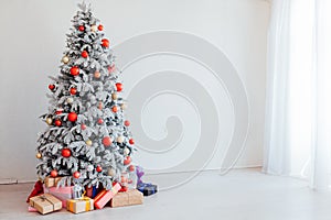 Christmas Decor Christmas tree with presents in a white room in winter