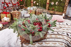 Christmas decor. Holiday basket with fir tree  branches and red balls on background og Christmas light. Winter holidays