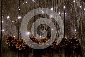 Christmas decor on a wooden board as a fonds with a garland and Christmas cones as a background