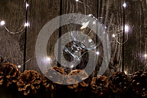 Christmas decor on a wooden board as a fonds with a garland and Christmas cones as a background