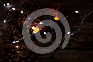 Christmas decor on a wooden board as a fonds with a garland and Christmas cones as a background