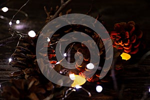 Christmas decor on a wooden board as a fonds with a garland and Christmas cones as a background