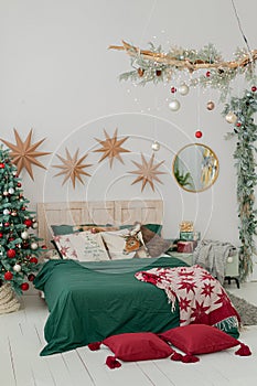 Christmas decorated bedroom in classic green and red colors. Classic Christmas tree decorations