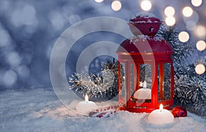 Christmas decorated lantern and candles on snow with copy space