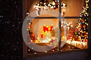 Christmas Decorated Room Interior with Garland Lights, Candles and Fir Tree. Winter Frosted Window Frame. Xmas Holiday Gingerbread